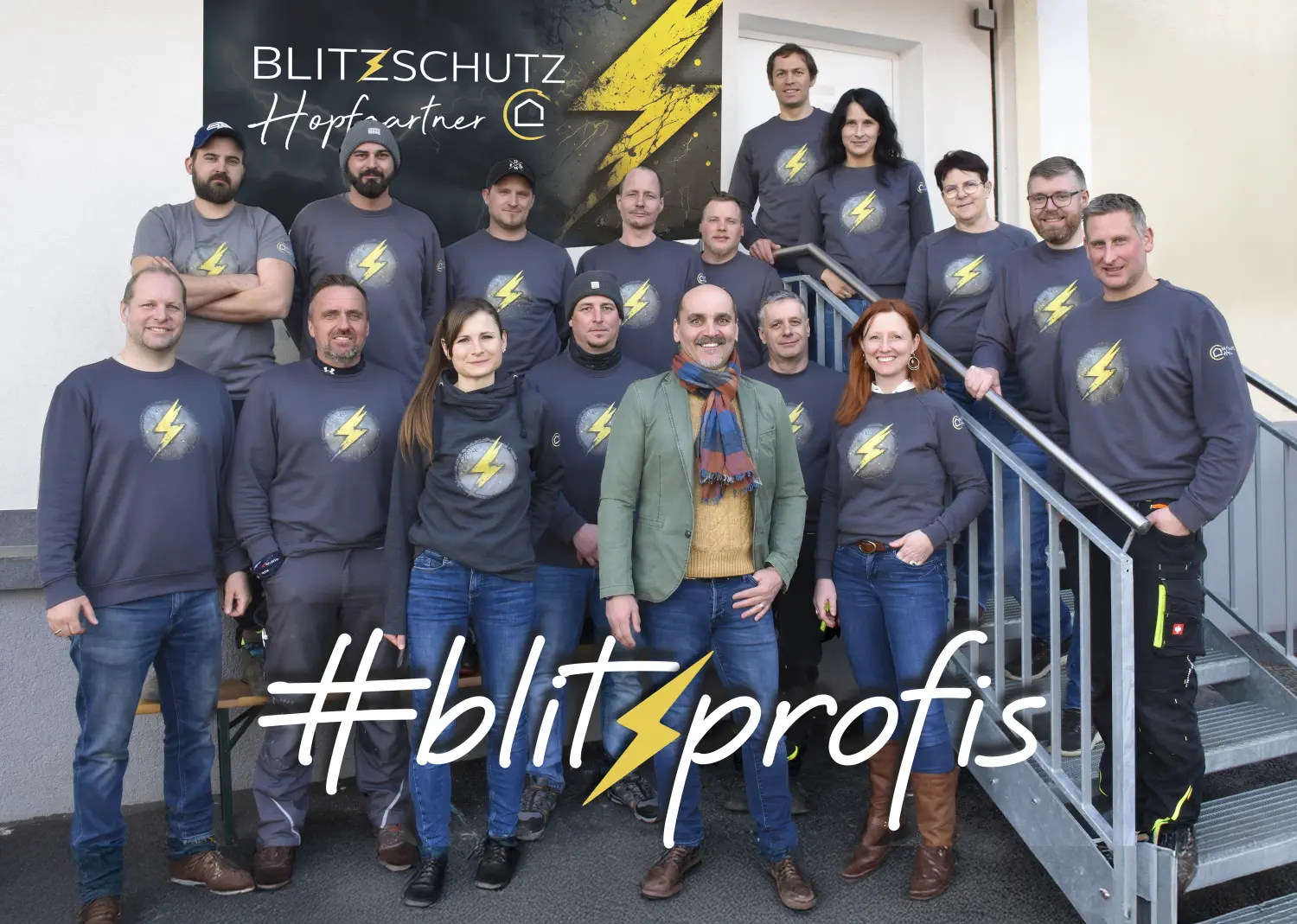 Das gesamte Team von Blitzschutz Hopfgartner steht vor dem Büro und lächelt in die Kamera
